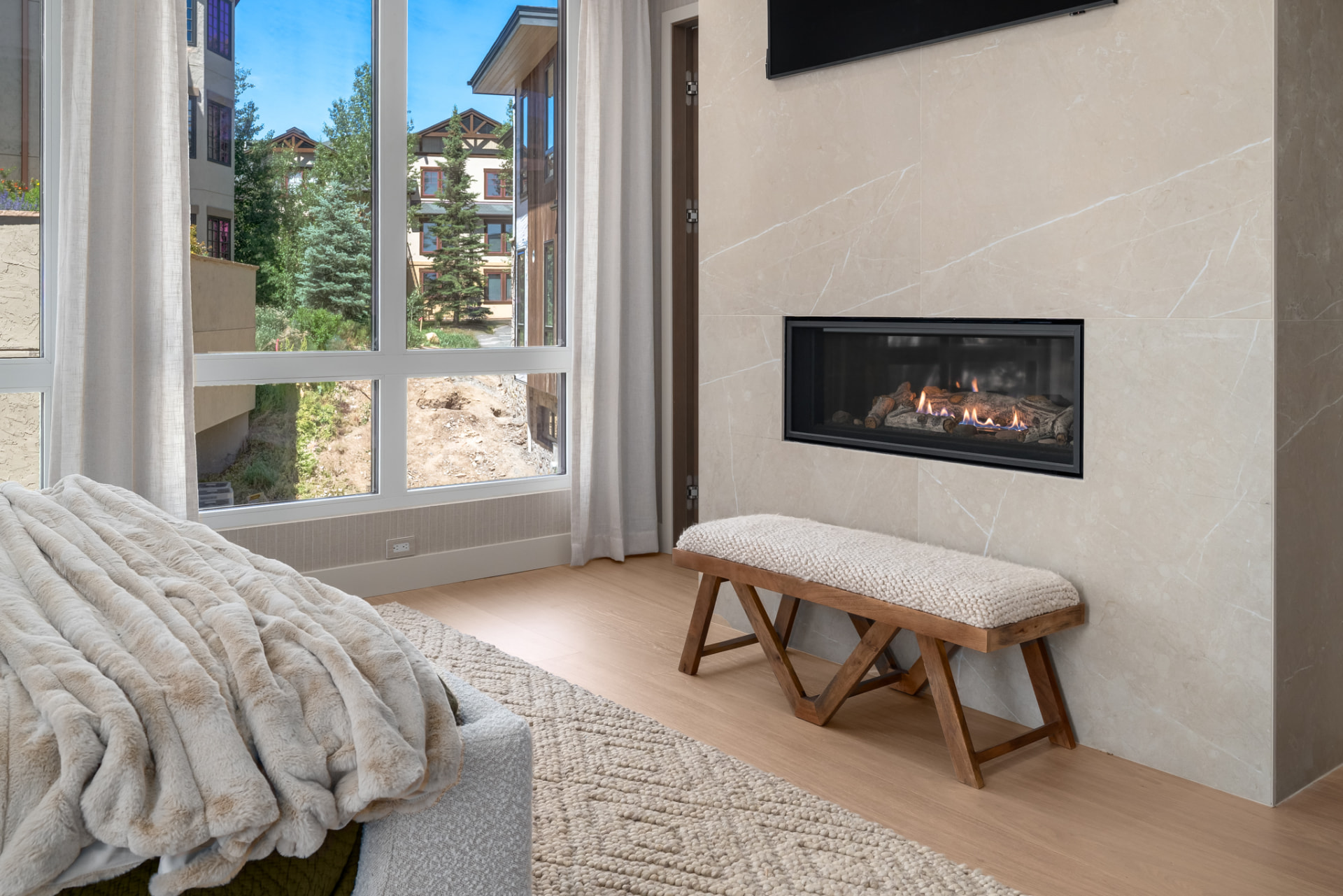 Primary suite sitting area with marble-clad linear fireplace and mountain outlook