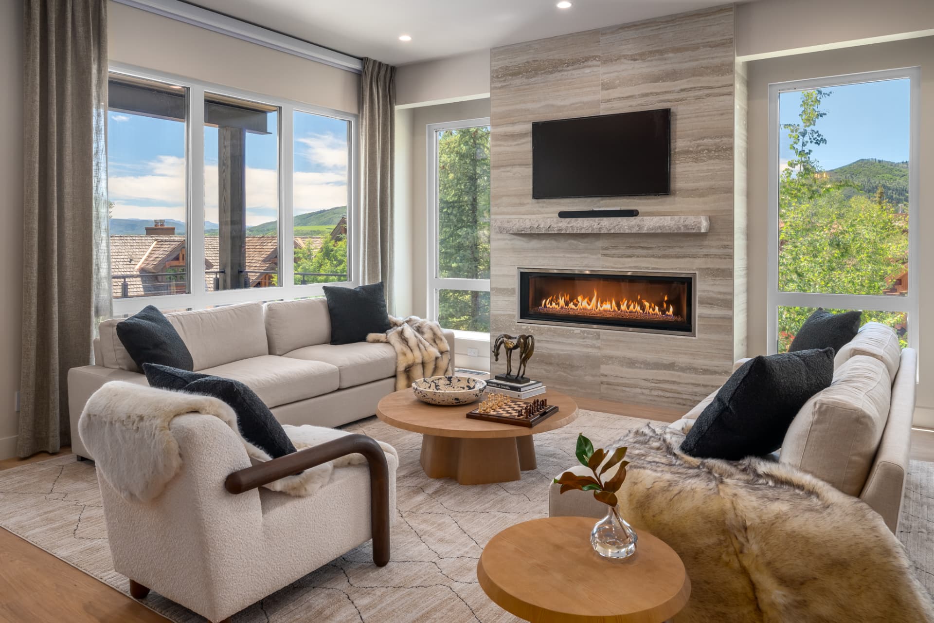 Living room seating with linear gas fireplace and windows framing the ski mountain