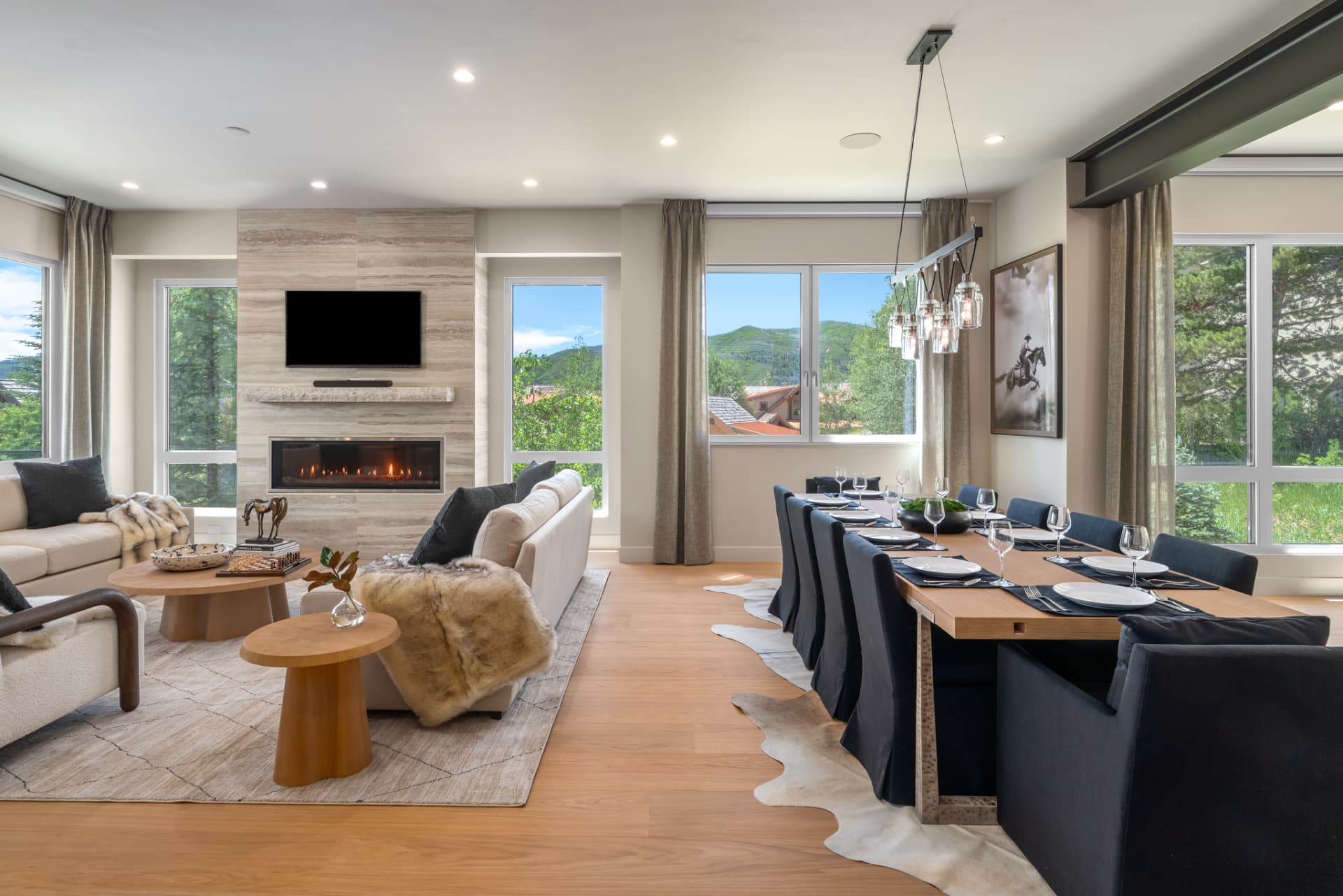 Open great room and dining area with cowhide rug and pendant lighting