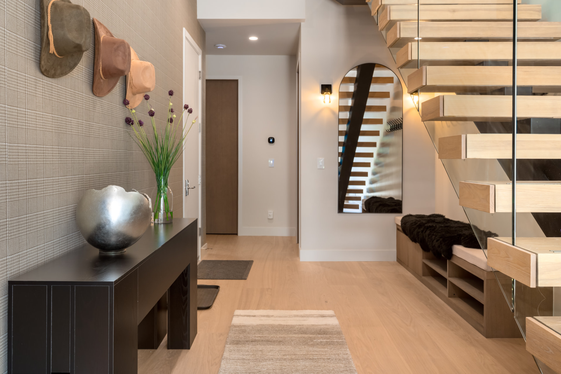 Entry hall with built-in bench, custom millwork and grasscloth walls