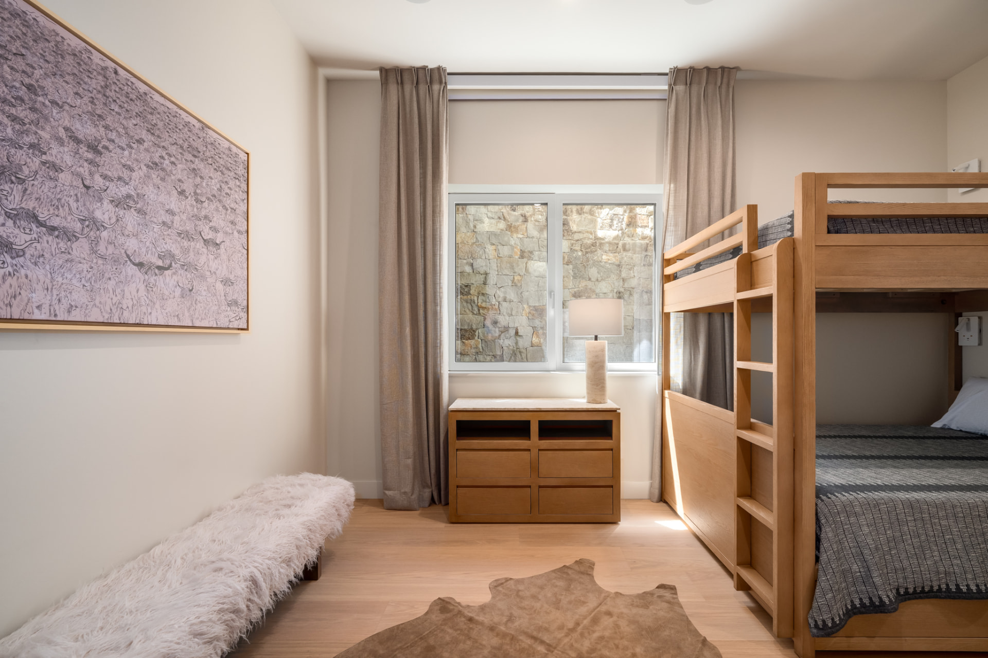 Bunk room with custom white oak bunks, artwork and hide rug