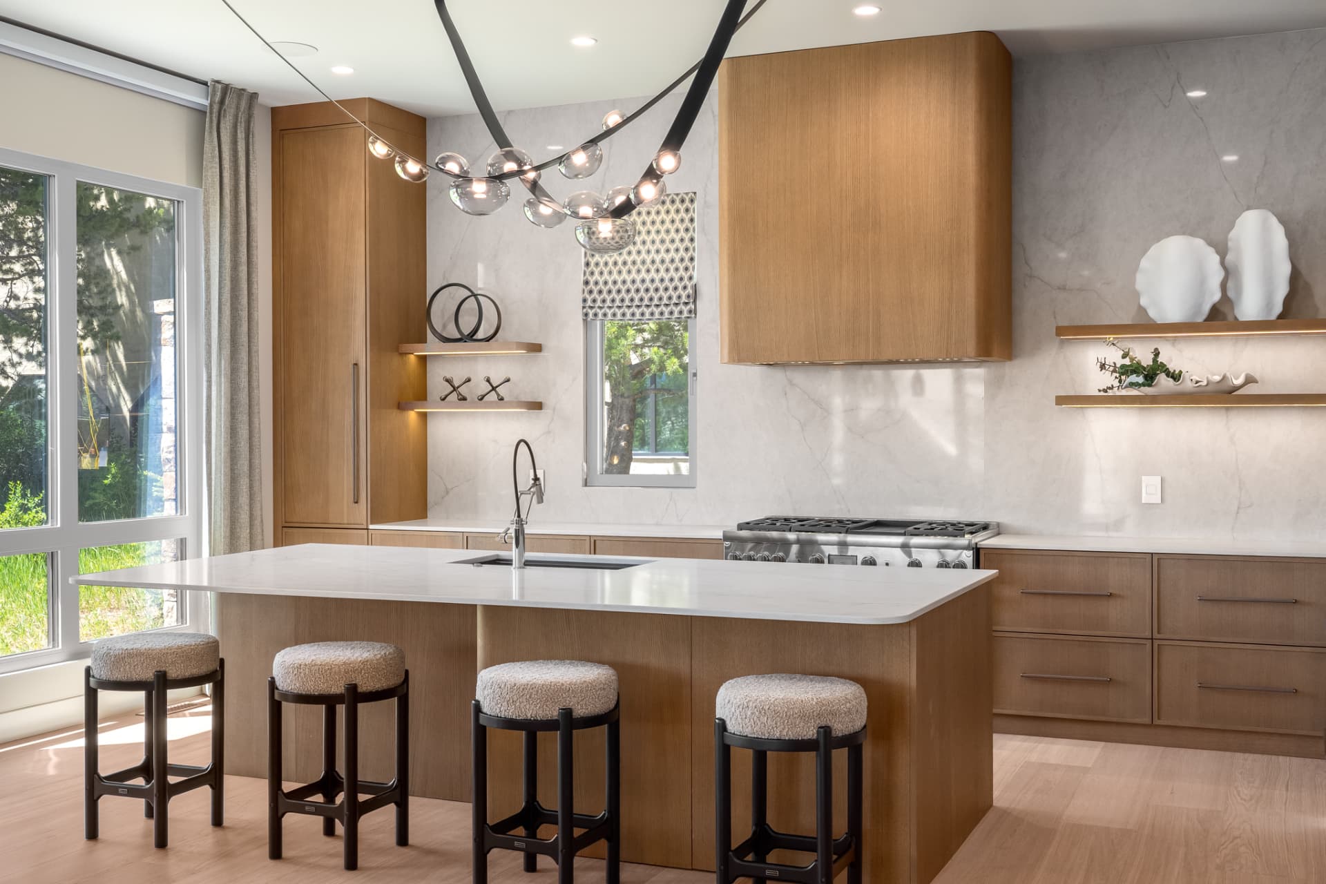 Chef's kitchen with white oak cabinetry, marble backsplash and quartz island seating